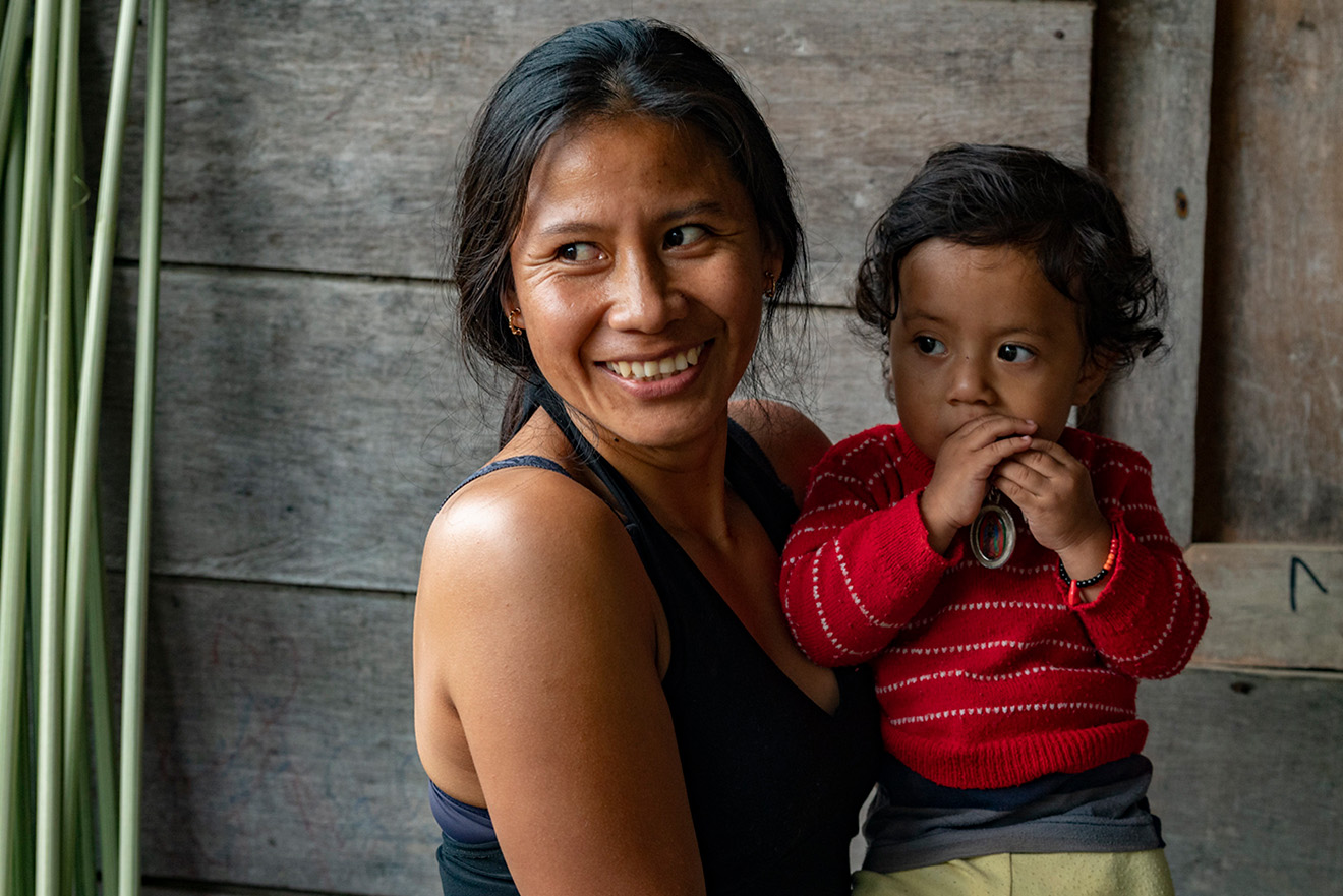a smiling woman holds a kid
