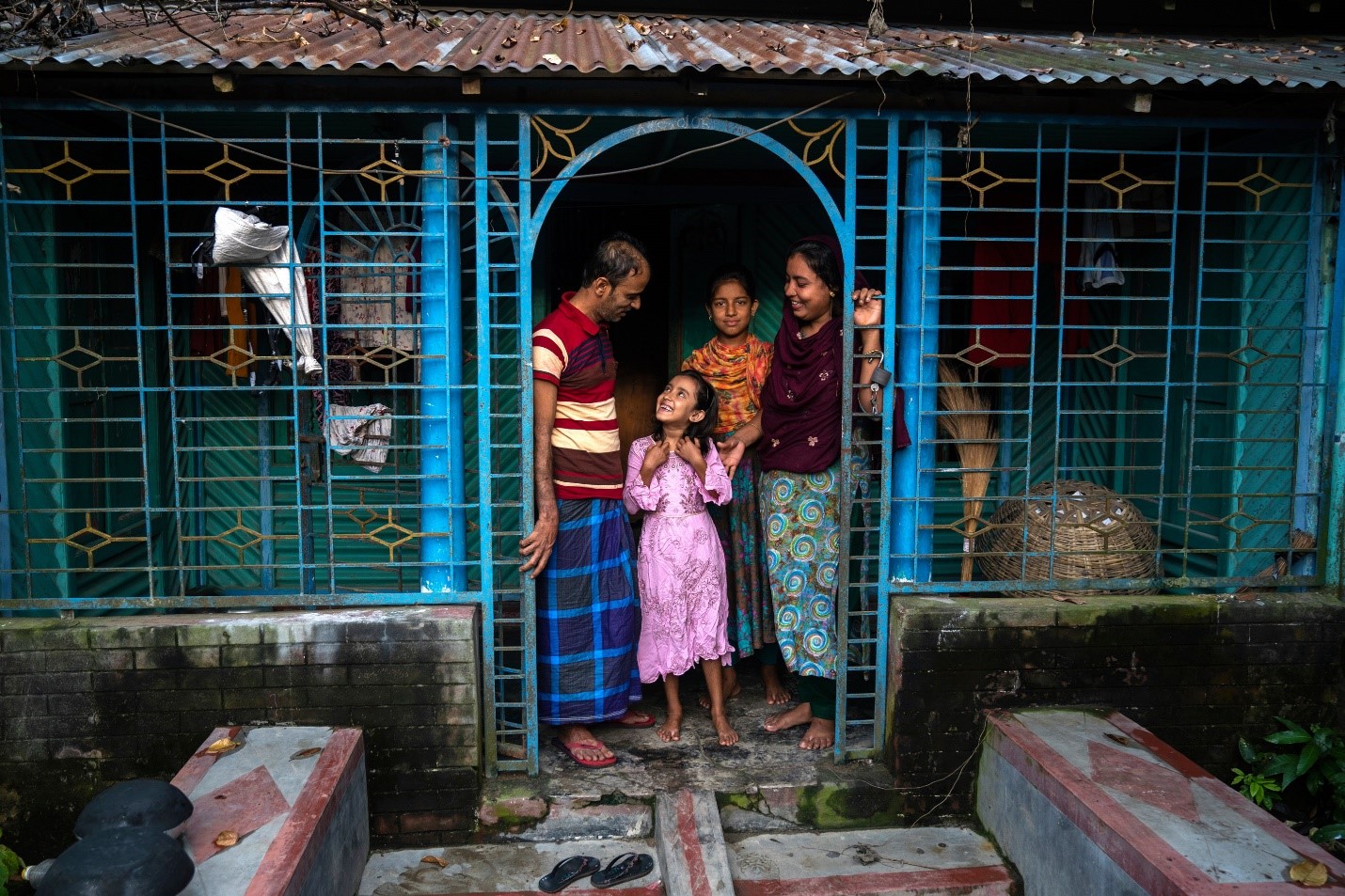 Father, mother and two girls standing in a doorway 