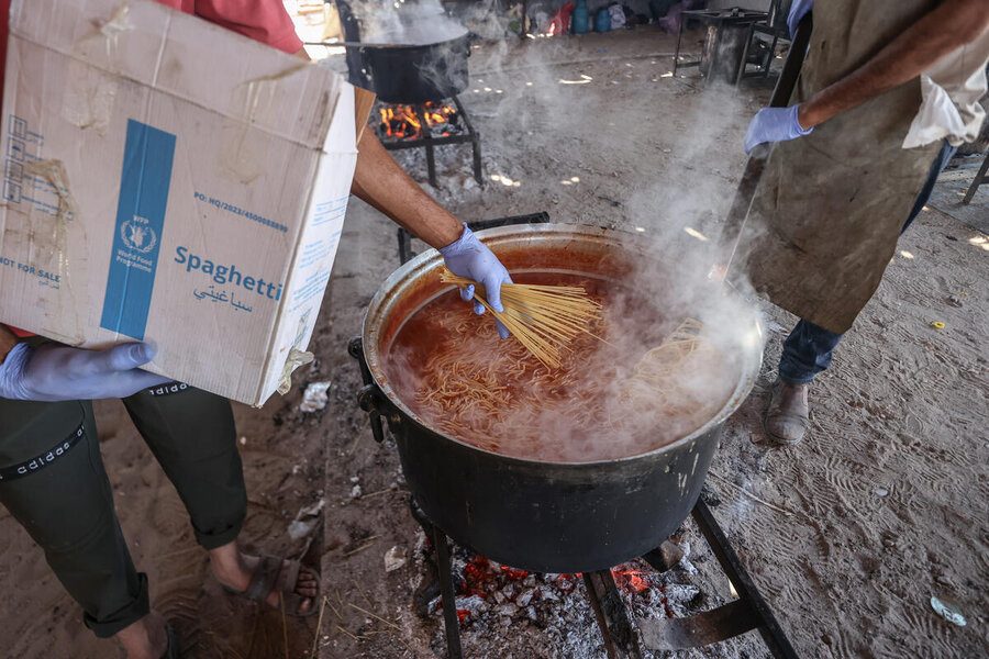 person boiling spaghetti in big pot
