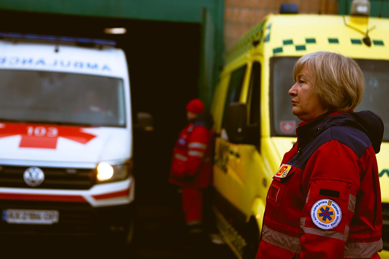 Female Ukrainian anesthesiologist-reanimatologist walking between ambulances.